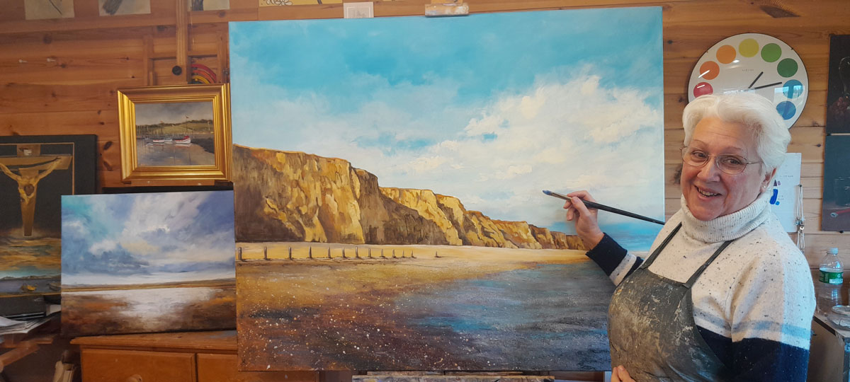 Adding the finishing touches to an oil painting of the cliffs at Sheringham